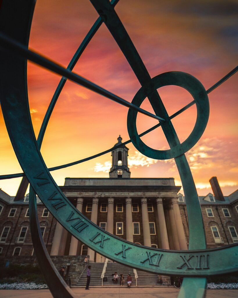 Stunning view through an armillary sphere of Penn State's main building at sunset